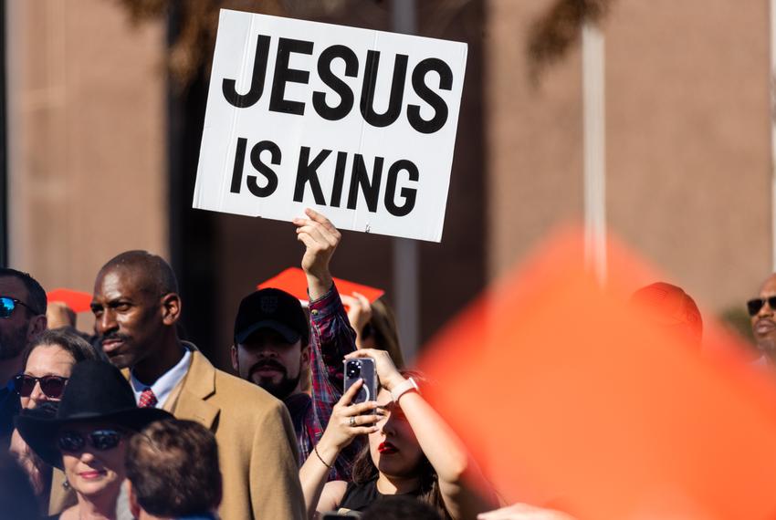 Lt. Gov. Dan Patrick calls attention to a man holding a sign labeled "Jesus is king", and praising him for putting his faith first, while he delivers his Inaugural address after taking the Oath of Office at the state Capitol in Austin on Jan. 17, 2023.