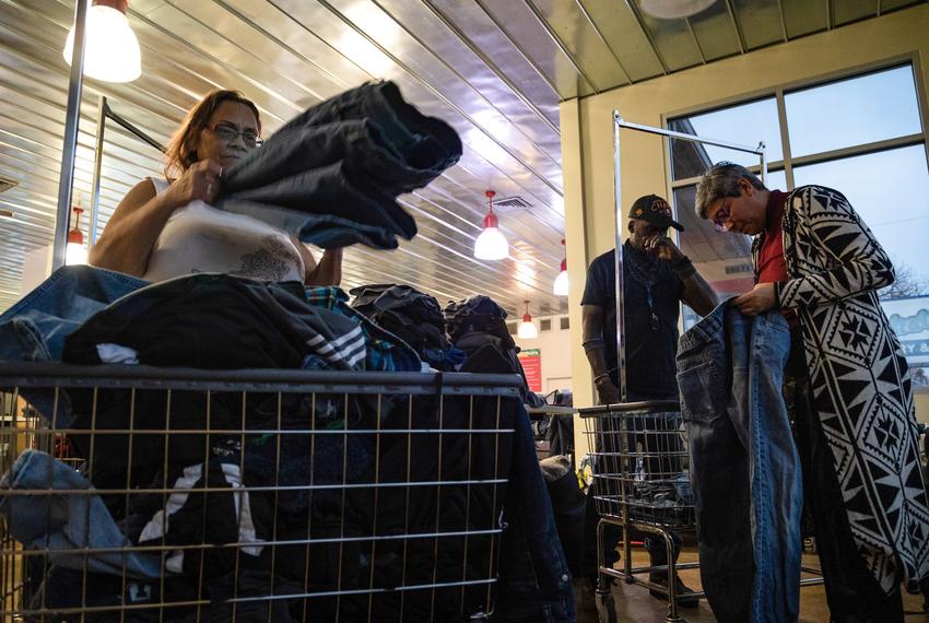 Linda Jackson, Corey Roberson and Sasha Rose, an organizer with Austin Mutual Aid, all fold clothing at the Washatopia laundromat in Austin on Feb. 7, 2023. “We provided the blankets, but [the help] shouldn’t stop there. What we’re trying to do is fill in the gaps,” said Rose, explaining just giving people blankets without support for caring for their things just creates another problem.