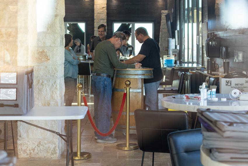 Ballots are counted by hand on top of wine barrels at The Edge in Fredericksburg on Mar. 5, 2024. Poll workers have been hand counting early voting ballots since 7 a.m.