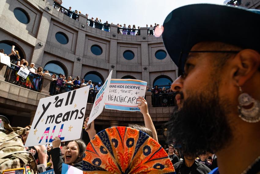 People line the railing on all three levels of the outdoor rotunda of the state Capitol in Austin, and wave signs during the "Fight for our Lives" rally in opposition of anti-LGBTQ+ bills on March 27, 2023.