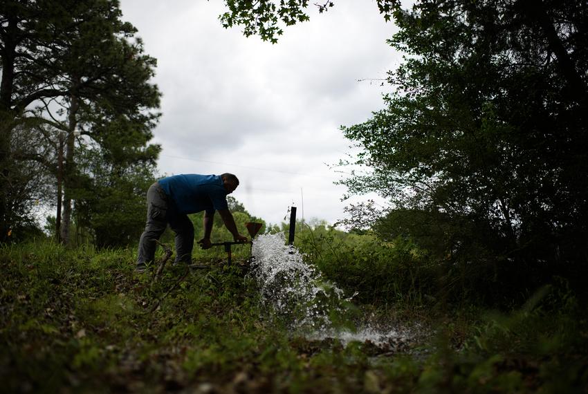 Tom Bailey flushes out a water line in Zavalla on April 10, 2023.