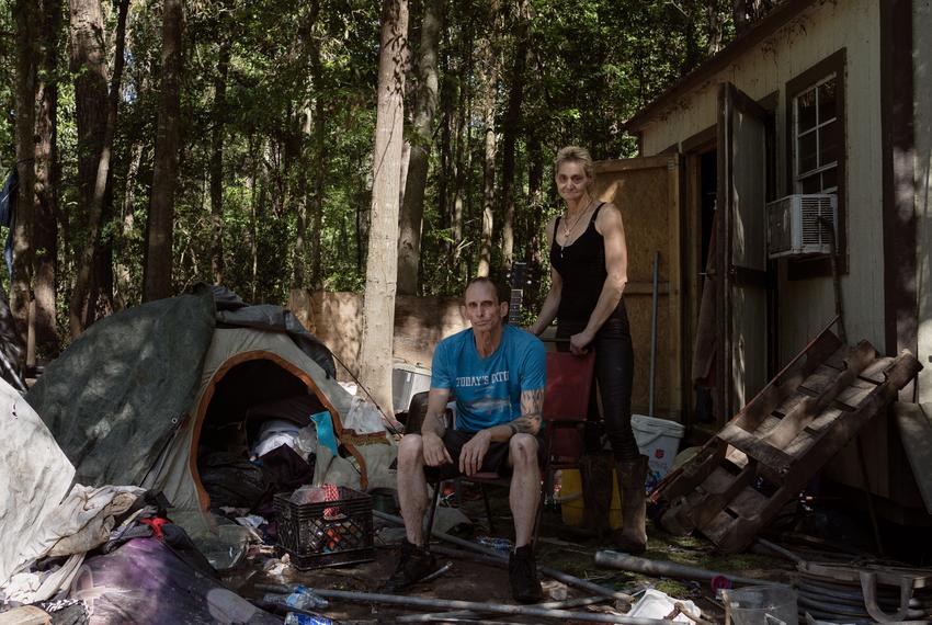 A portrait of Rodger Pace, 55, left, and Veronika Scheid, 51, right, next to the tent where they’re currently living in Harris County outside Houston, Texas, on May 14, 2024. The small building they were living in was completely damaged by flooding.