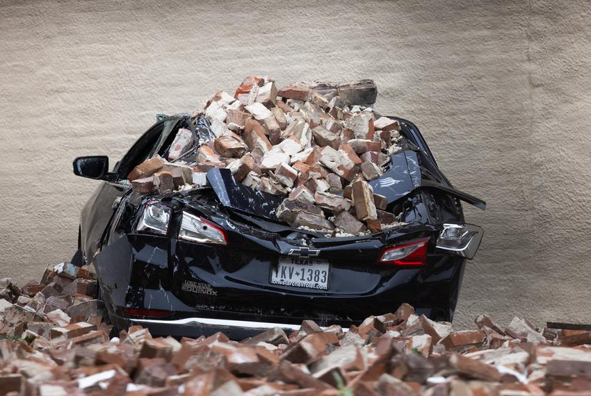 A car roof is flattened after bricks from a partially collapsed wall of Conejo Malo fell on it in downtown, Friday, May 17, 2024, in Houston. (Antranik Tavitian / Houston Landing)