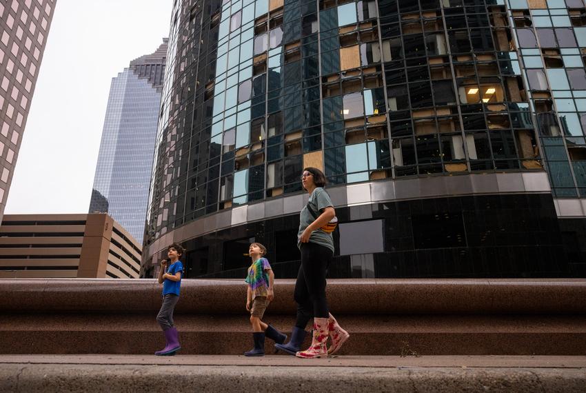 The Muncy family looks at damaged buildings in downtown after a storm broke windows in many of the skyscrapers on Louisiana Street, Friday, May 17, 2024, in Houston. (Antranik Tavitian / Houston Landing)