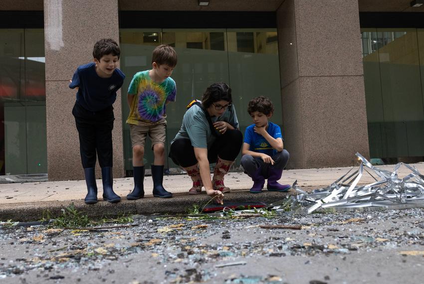 From left, Luke, 8, Ryan, 6, Jaqueline, and Tanner Muncy, 6, look at the damage and debris on Louisiana Street the morning after a storm in downtown, Friday, May 17, 2024, in Houston. (Antranik Tavitian / Houston Landing)