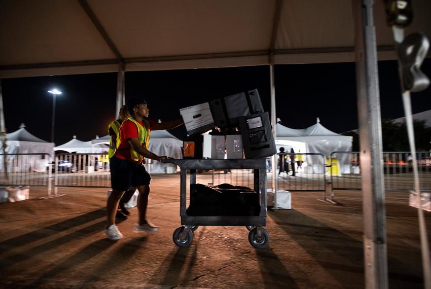 A Harris County election worker carries in ballots and voting supplies from a polling location at NRG Arena Tuesday, May 24, 2022, in Houston, Texas.