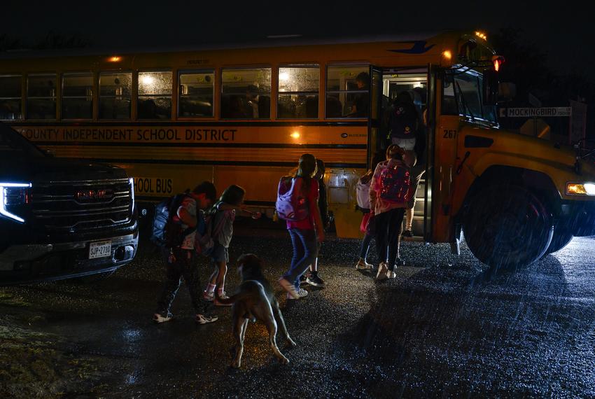 Children in West Odessa line up to board their school bus before dawn on Tuesday, Sept. 12, 2023.