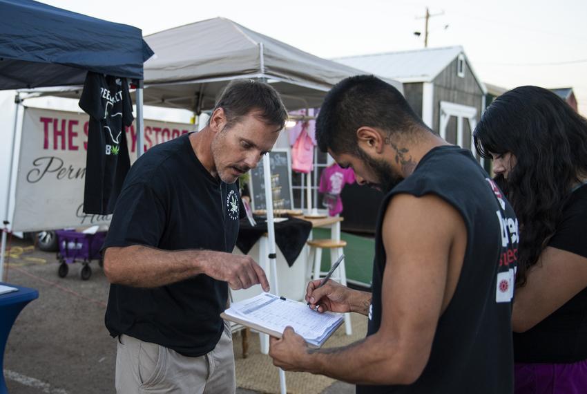 Nathan Lewis gets signatures on a petition to to legalize marijuana from Andrew Alcala, center, and Yvette Castillo, right, at the South Plains Fair Monday, Sept. 25, 2023, in Lubbock, Texas.