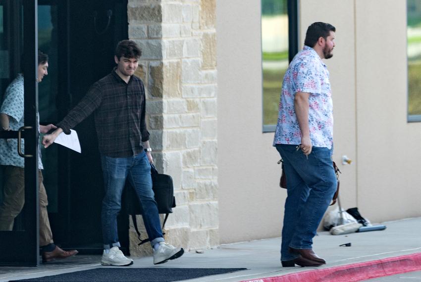 Nick Fuentes (middle) is seen exiting the offices of Pale Horse strategies with Chris Russo, founder and president of Texans for Strong Borders (right) in Fort Worth on Oct. 6, 2023.