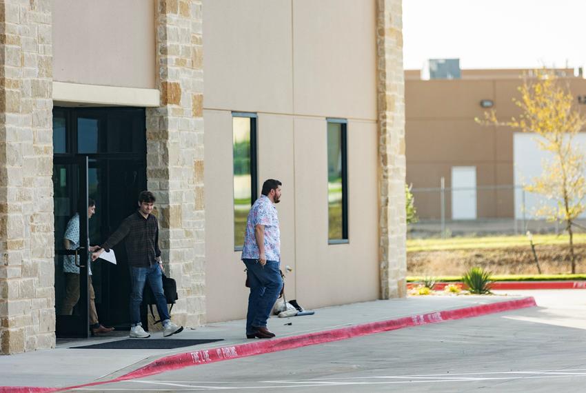 Nick Fuentes (middle) is seen exiting the offices of Pale Horse strategies with Chris Russo, founder and president of Texans for Strong Borders (right) in Fort Worth on Oct. 6, 2023.