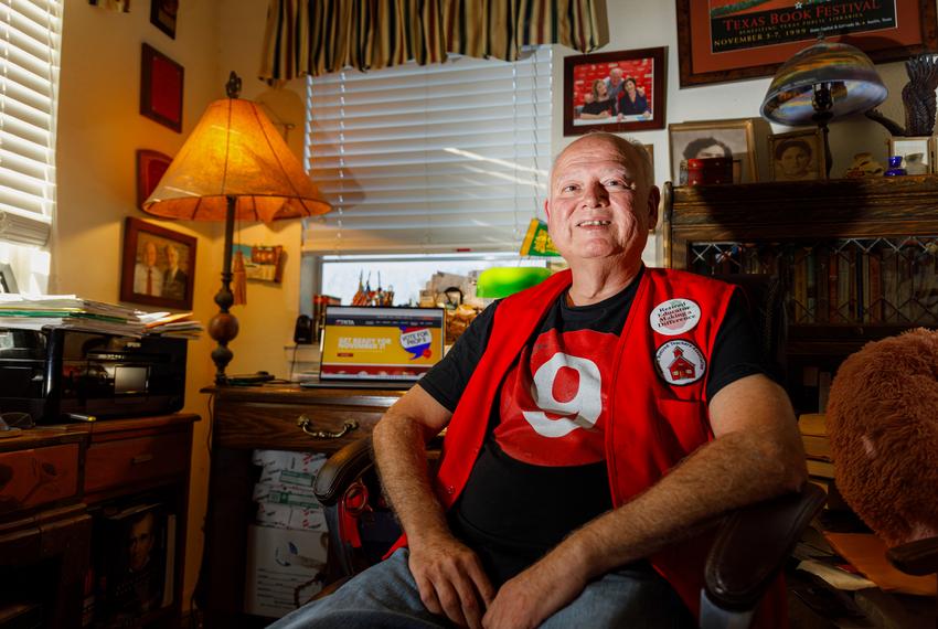 Retired educator Joe Ramirez sits at a desk surrounded by walls of photos and awards in his Austin home on Nov. 2, 2023.