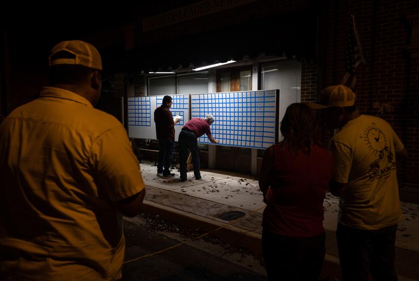 Residents watch Uvalde Leader-News reporters update results from local races on a white board in Uvalde on Election Day Nov. 8, 2022.