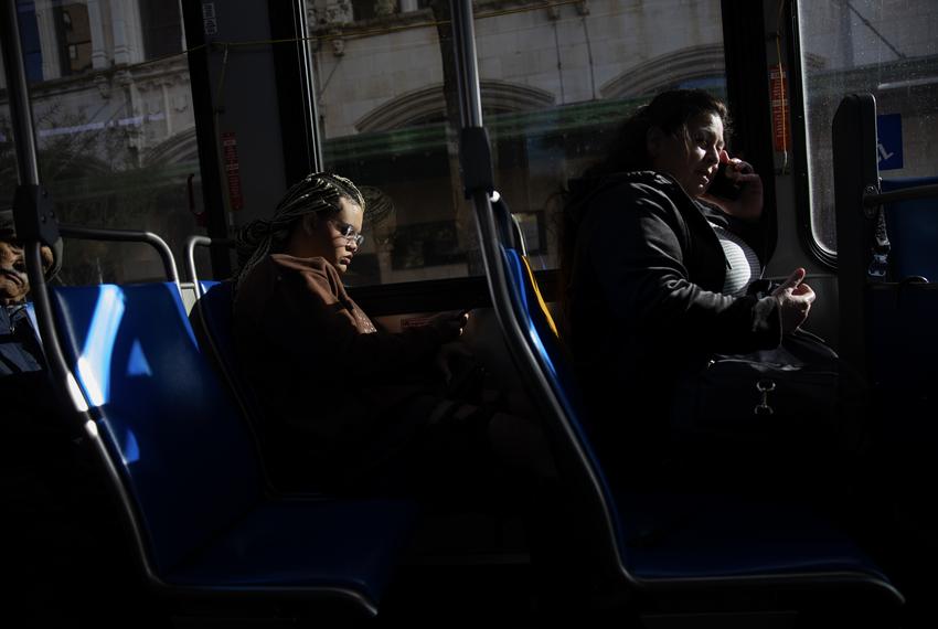 On Nov. 21, 2023, Isabella Morningstar looks at her phone on the bus on her way to Palo Alto College, which is 10 miles south of the youth shelter where she is staying.