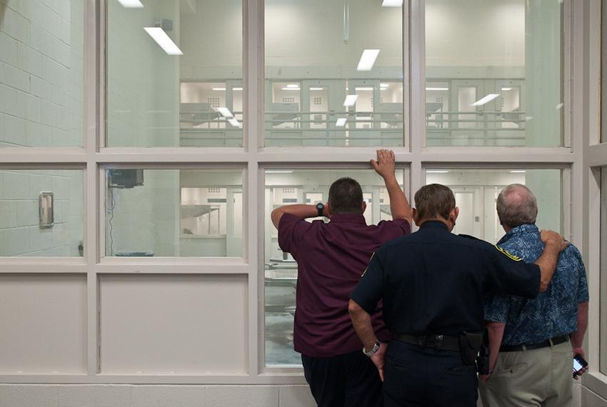 Jail officials watch as the ventilation system clears a day room of fumes released by a smoke bomb.