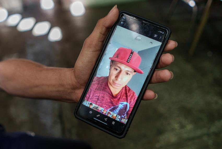 Alex Santos Jiménez, 20, from Honduras, shows a photo of his father, Alis Santos López, who was detained by Mexican immigration officials at the bus station in Ciudad Juárez and taken to the immigration detention center two days before the deadly fire.