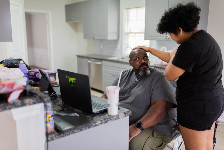 Kadence Carter, 17, caresses his father, William Carter, as they work on moving to a new League City home Feb. 16.