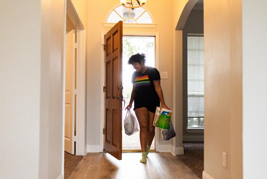 Kadence Carter, 17, carries groceries inside his new home with his father, William, on Feb. 16 in League City.