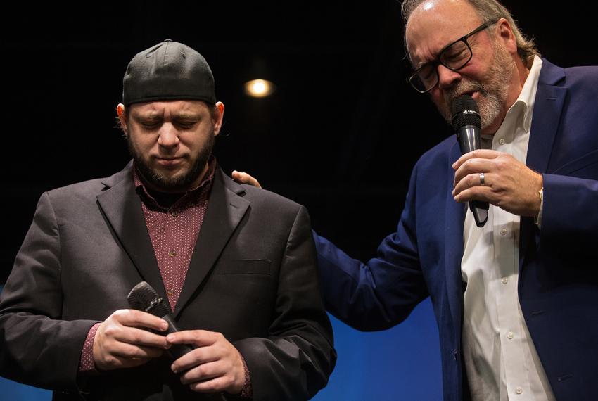 Mark Lee Dickson bows his head as Pastor Scott Beard prays during a worship service at the FountainGate Fellowship church in Abilene on Sunday.