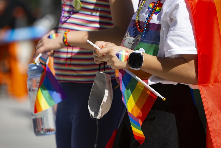 Kids hold flags and wear heart stickers and beads at the AISD "Pride Out!" Party in the Park event at Eastside Early College High School in Austin on Saturday, Mar. 26, 2022.