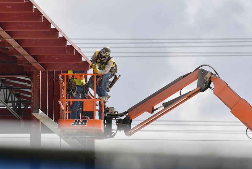 Construction workers work on an office building on the corner or Metric and Parmer in Austin on June 18, 2020.