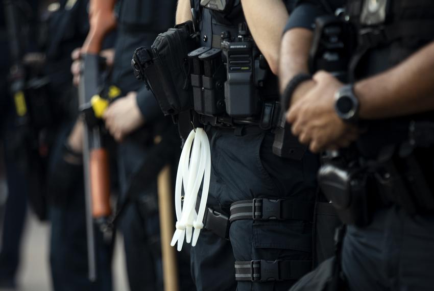 Austin police officers stand near an overpass on Interstate 35 to prevent protesters from blocking traffic during a rally at Austin police headquarters. 


