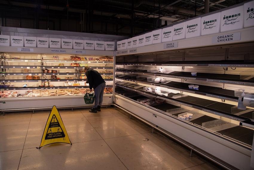 Customers look through nearly empty shelves of produce inside a Central Market grocery store in North Austin on Feb. 17, 2021.