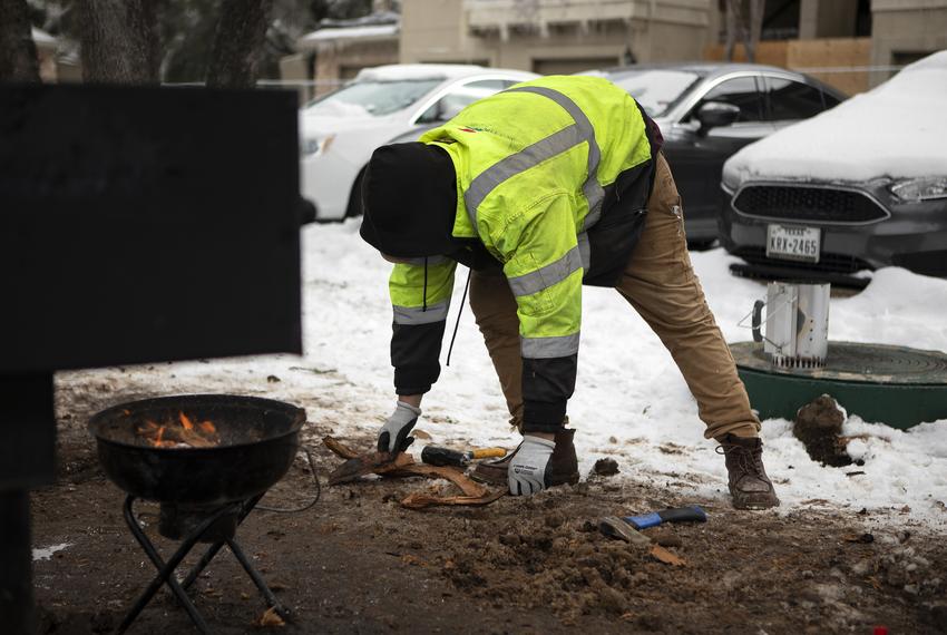 Jacob Duran prepares wood for a grill. Duran has been cooking meals outsides after his apartment lost power. Feb. 18, 2021.