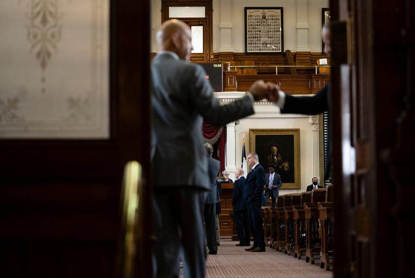 A legislator fist bumps a House Administration staffer as they entered the House Chamber on Aug. 11, 2021.