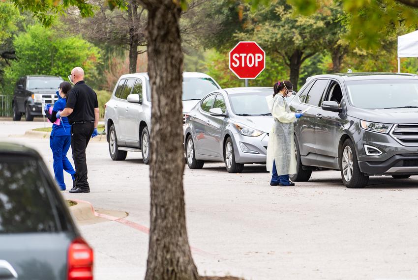 A doctor wearing protective clothing administers a test to patient at a drive-thru Covid19 testing facility at Baylor, Scott and White Medical Center in Round Rock, TX.