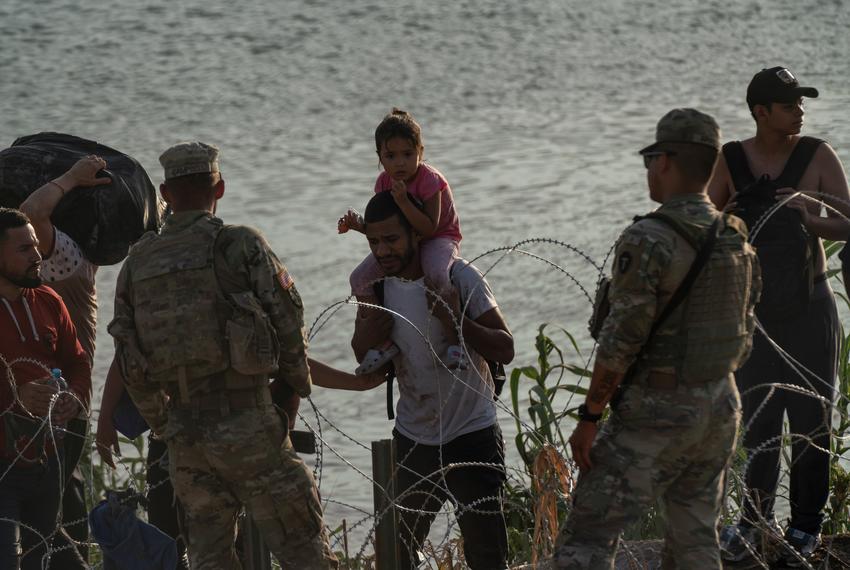 National Guard members tell migrants that they cannot cross through that area and that they need to walk until the end of the property to turn themselves in Eagle Pass, Texas on July 29, 2023. As there is concertina wire installed along the Urbina’s property, migrants are told to walk to the end of the property. Many make that walk which can be difficult to do through slippery rocks in the water, the current and the inclined river bank, while some find spots through the concertina wire and manage to get through. Some will be sent back after being arrested for trespassing private property without allowing them to go through the immigration process in the U.S.
Verónica G. Cárdenas for The Texas Tribune