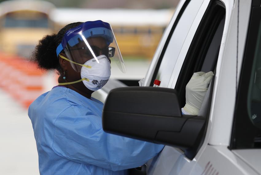 Harris County Health Department nurse Harriet Lewis administers a test at a Harris County testing site located at Stallworth Stadium in Baytown on March 21, 2020.