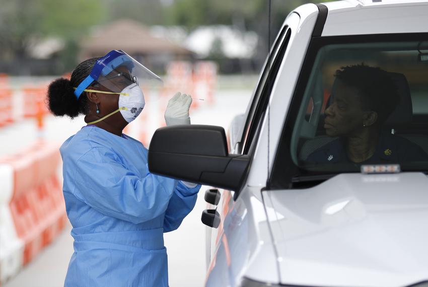 Harris County Health Department nurse Harriet Lewis administers a COVID-19 test at Stallworth Stadium in Baytown on March 21, 2020.