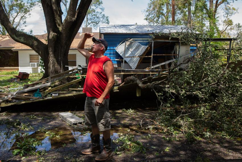 Drainage foreman Robert Walker scans the side of his house for storm damage after Hurricane Laura blew through Orange.