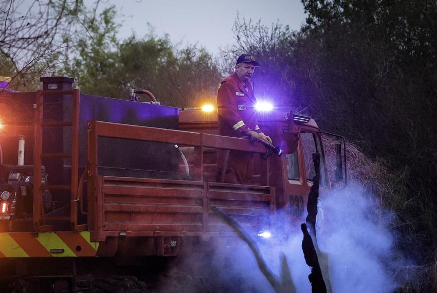 A firefighter with Nueces County Fire Rescue surveys the burnt brush on March 31, 2022. According to the Texas A&M Forest Service, a wildfire nearly 60,000 acres big, which was named the Borrega wildfire, burned through the King Ranch and surrounding areas.