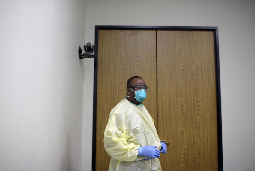 John Carter, Environmental Services Supervisor, practices the proper technique for putting on safety equipment during a training session in Houston.