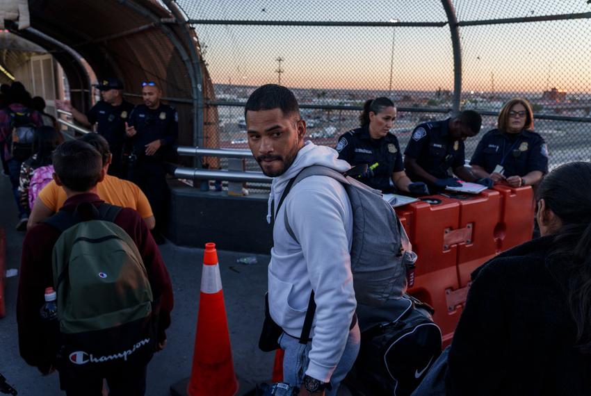 Arango looks back to Mexico one last time before he crosses into the United States. Arango, along with his wife and others who survived the fire, were granted permission to enter the United States for humanitarian reasons.