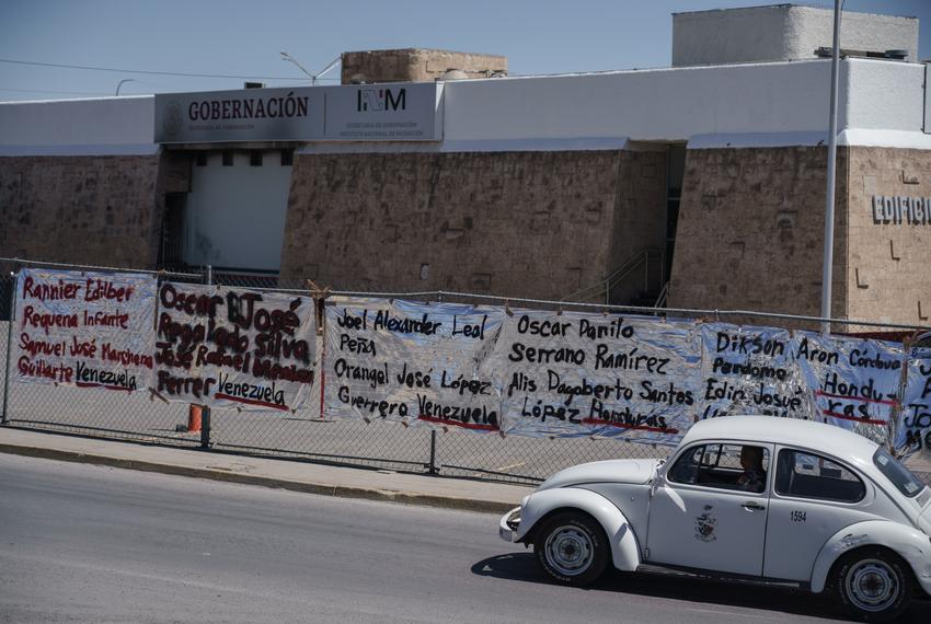 The names of the migrants killed in the 2023 fire, including Alis Santos López, are written on mylar blankets on the fence surrounding the detention center that burned to mark the one-year anniversary of the incident.