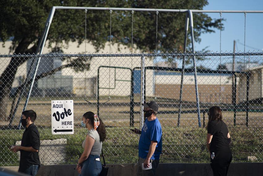 Voters wait in line outside Cody Public Library in San Antonio during the evening hours of Election Day on Oct. 23, 2020.