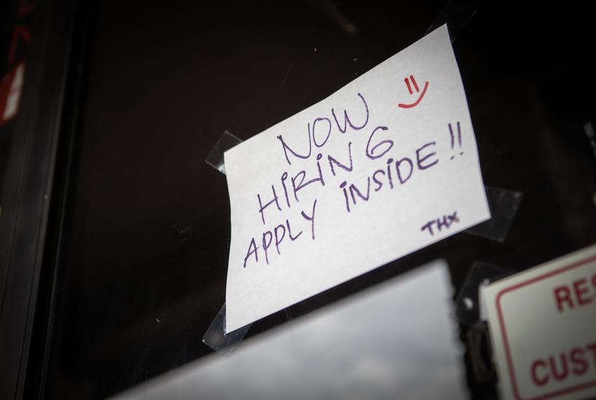 A "now hiring" sign is seen in the window of Toro Ramen and Poke Barn April 10, 2020 in San Marcos.