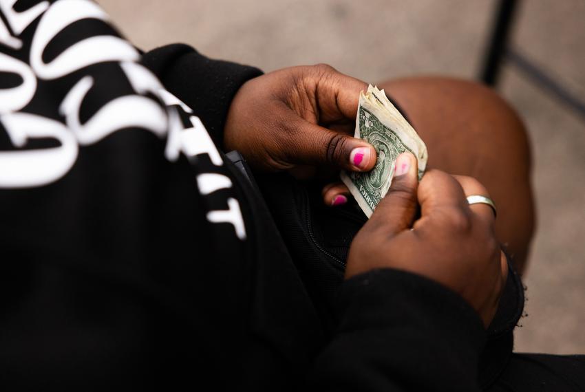 Stephen holds a few dollars before offering the cash to Montrose Street Reach.