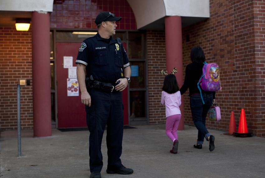 Austin Police Officer Cory Ehrler monitors the entrance to Ridgetop Elementary School after classes start on the Monday following the Sandy Hook Elementary School shooting. As the 83rd legislative session approaches, Texas lawmakers are considering making firearms more available to teachers and other school personnel.